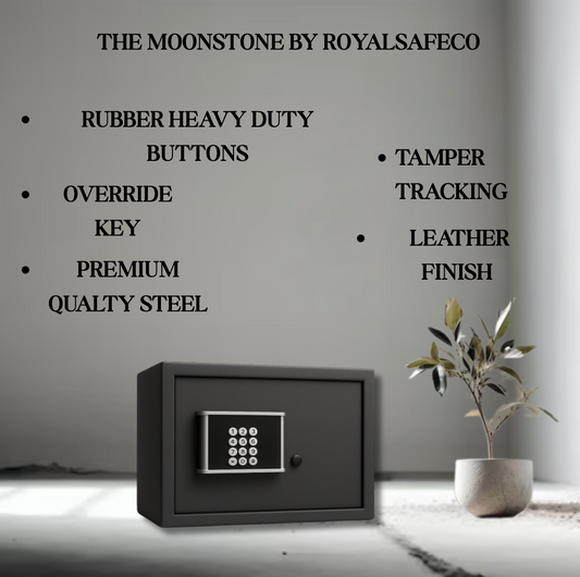 Black Moonstone safe by RoyalSafeco with keypad, rubber buttons, premium steel, tamper tracking, leather finish next to potted plant in grey room